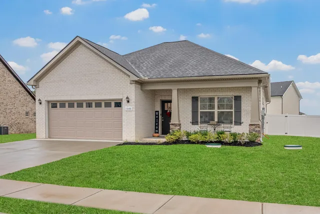 a front view of a house with a garden and yard
