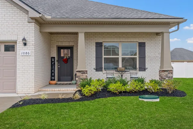 a front view of a house with a garden and plants