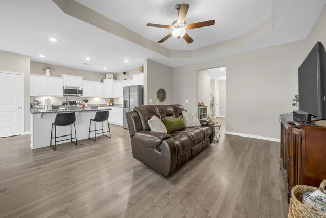 a living room with furniture a flat screen tv and kitchen view