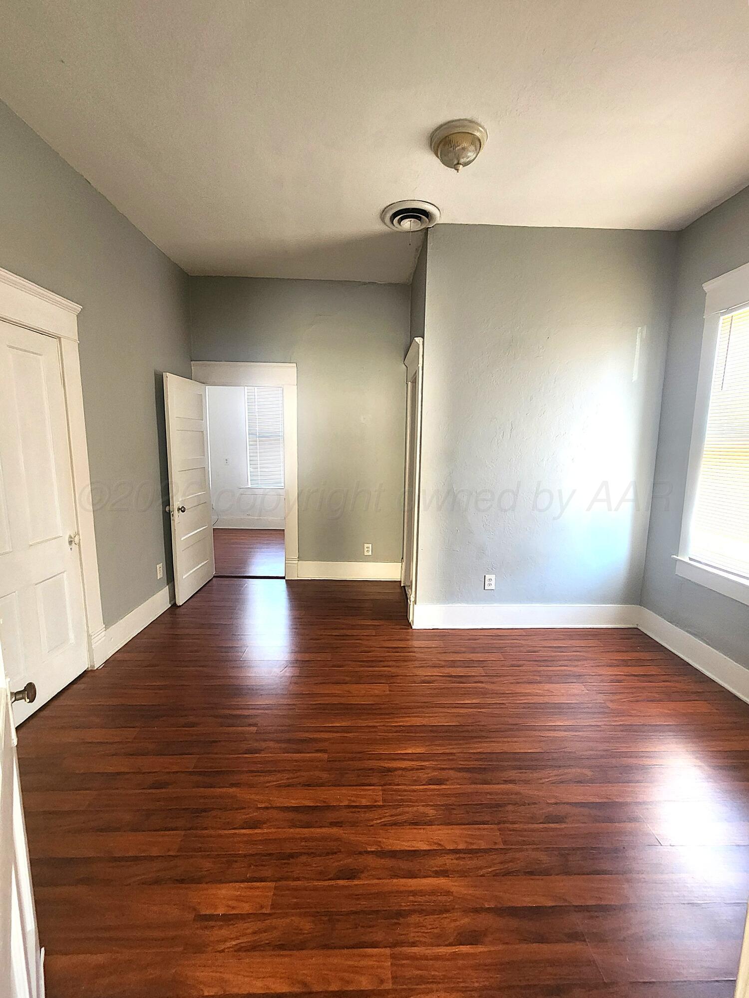 1108 South Lincoln Street Amarillo, TX 79101 - Photo 19 of 25 a view of an empty room with window and wooden floor