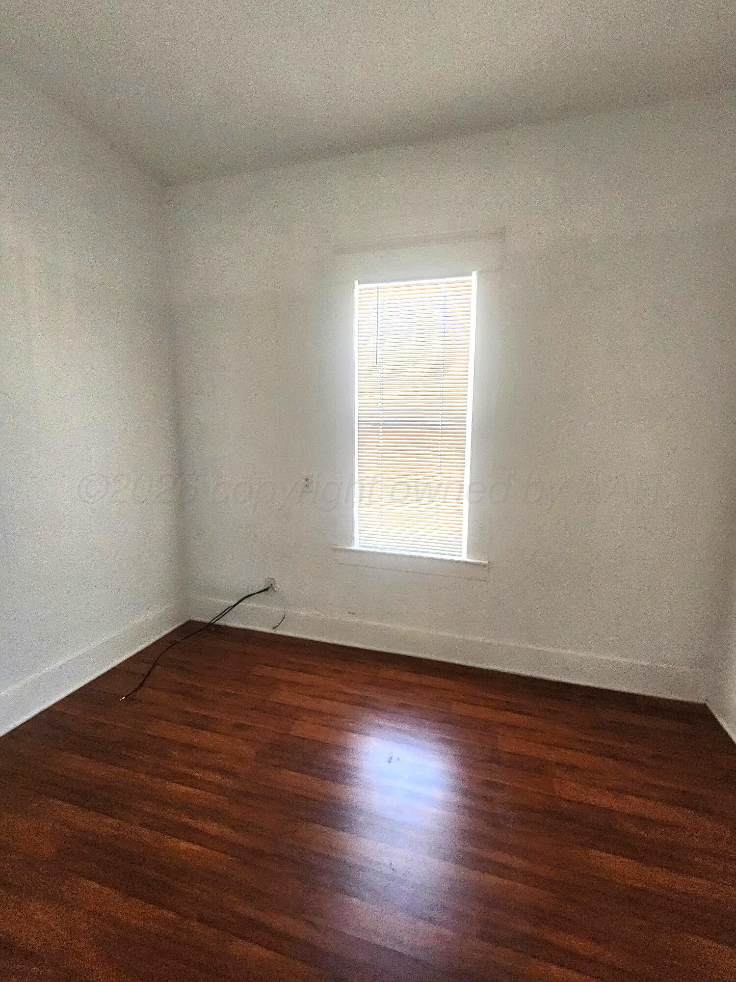 1108 South Lincoln Street Amarillo, TX 79101 - Photo 23 of 25 a view of an empty room with wooden floor and a window