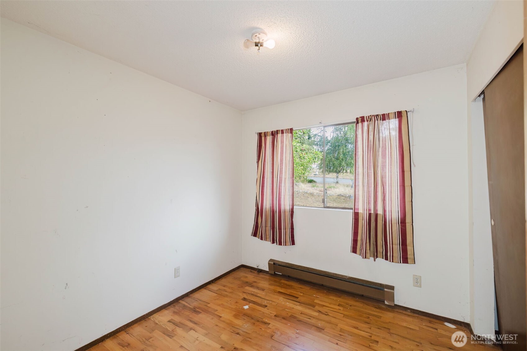 567 Juniper Street Bremerton, WA 98310 - Photo 18 of 37 a view of an empty room with wooden floor and a window