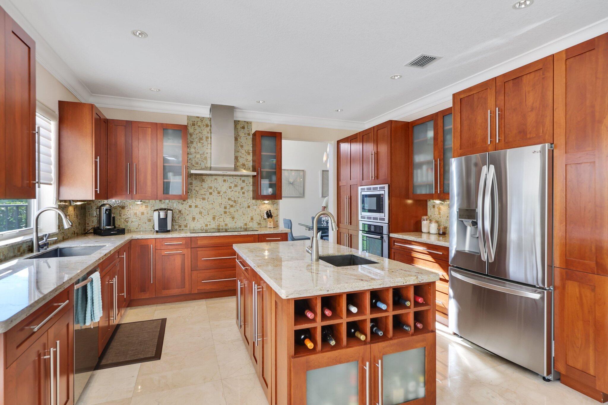 19245 Skyridge Circle Boca Raton, FL 33498 - Photo 26 of 70 a kitchen with stainless steel appliances granite countertop a refrigerator a sink dishwasher a stove with wooden cabinets and floor