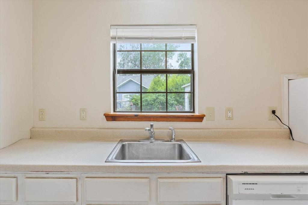 608 9th Street Hico, TX 76457 - Photo 9 of 23 Kitchen area featuring a stainless steel sink, light-toned countertop, and white cabinetry
