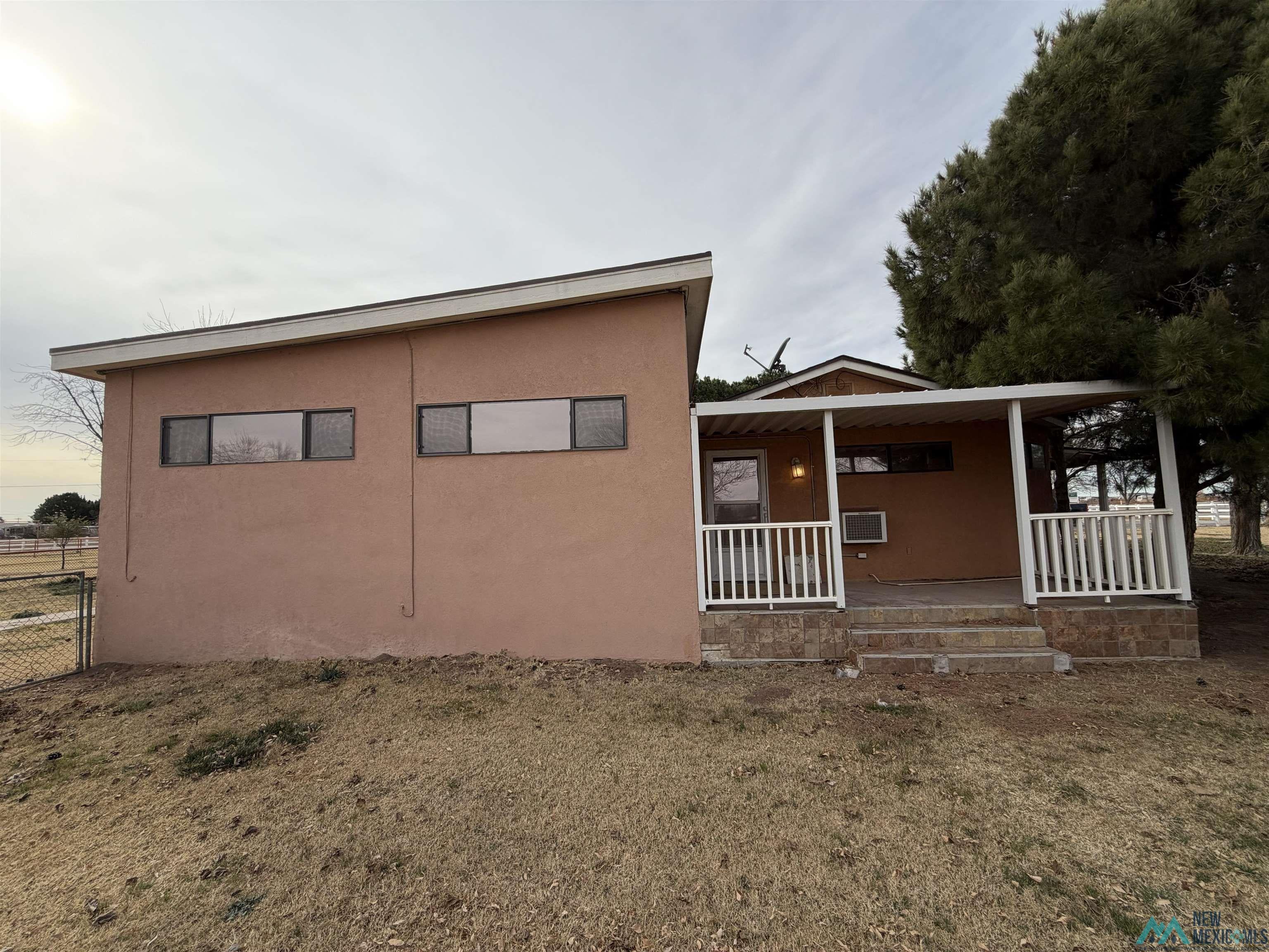 2001 East Derrick Road Carlsbad, NM 88220 - Photo 28 of 84 View of side of home with a porch and stucco siding