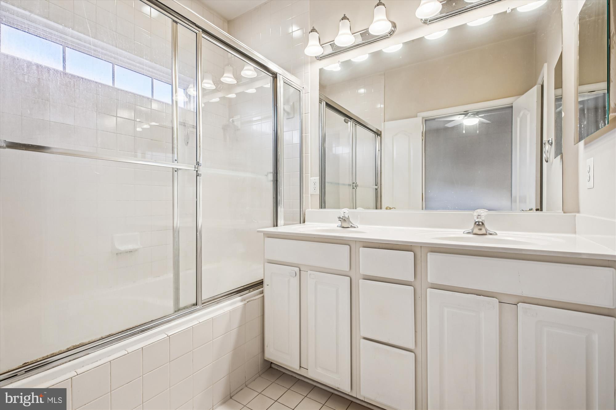1127 Gaither Road Rockville, MD 20850 - Photo 17 of 36 a bathroom with a double vanity sink a mirror and a shower