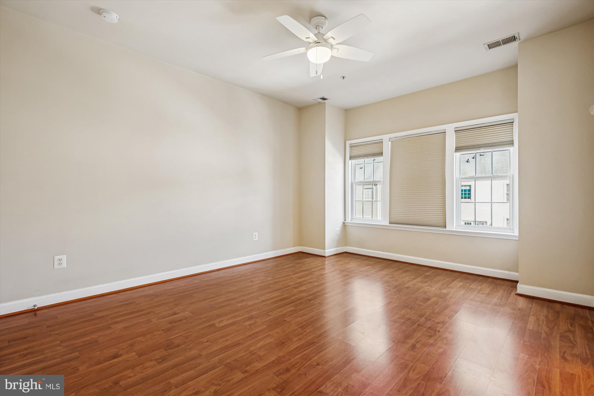 1127 Gaither Road Rockville, MD 20850 - Photo 20 of 36 a view of an empty room with wooden floor and a window