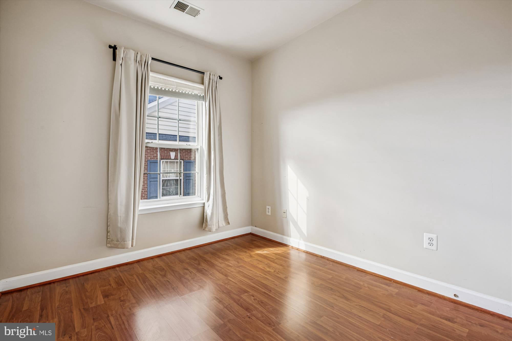 1127 Gaither Road Rockville, MD 20850 - Photo 21 of 36 an empty room with wooden floor and windows