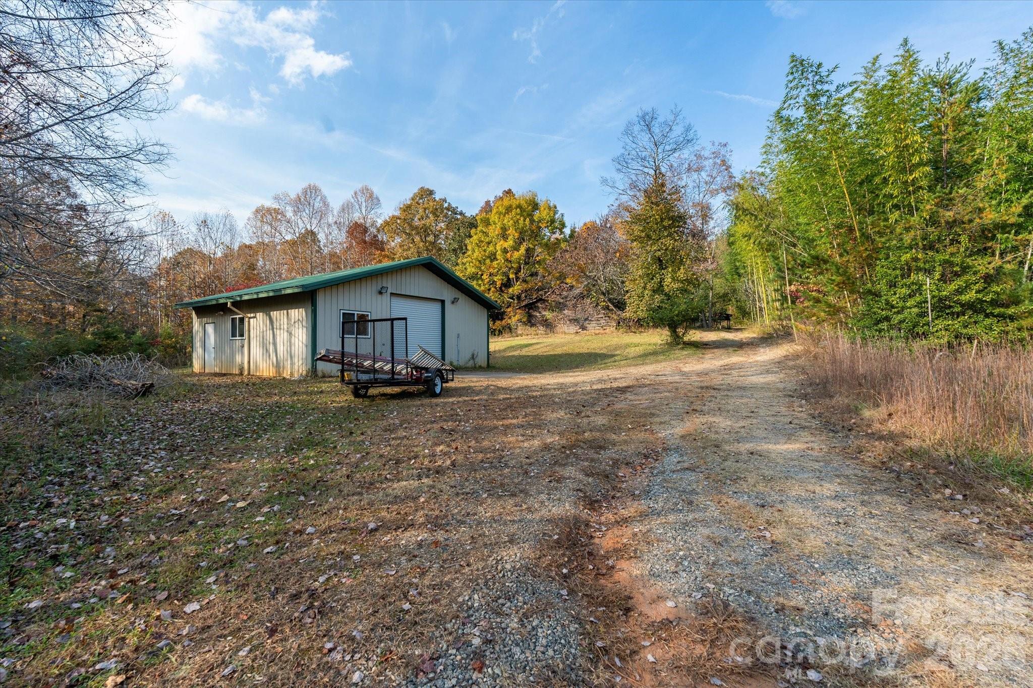 1888 Pea Ridge Road Mill Spring, NC 28756 - Photo 22 of 31 a front view of a house with a garden and trees