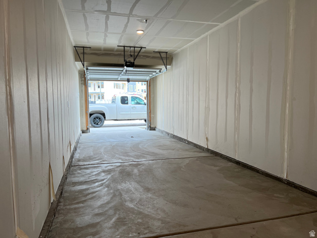 717 West W Coho Lane South, Unit 2F302 Midvale, UT 84047 - Photo 2 of 22 Single-car garage with a concrete floor, unfinished drywall walls, and an overhead garage door
