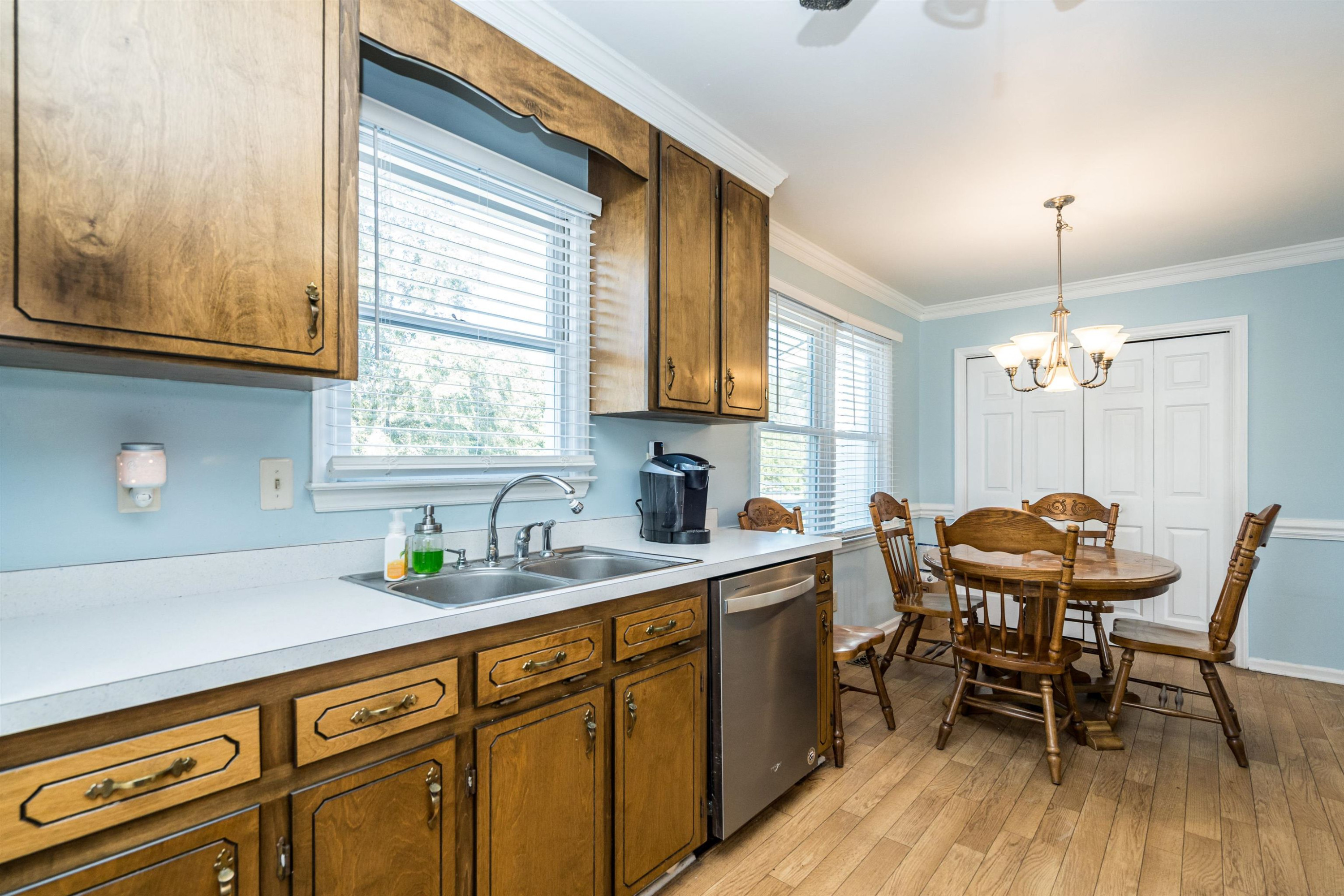 429 Government Road Clayton, NC 27520 - Photo 14 of 27 a kitchen with stainless steel appliances granite countertop a sink dishwasher a microwave oven a dining table and chairs with wooden floor