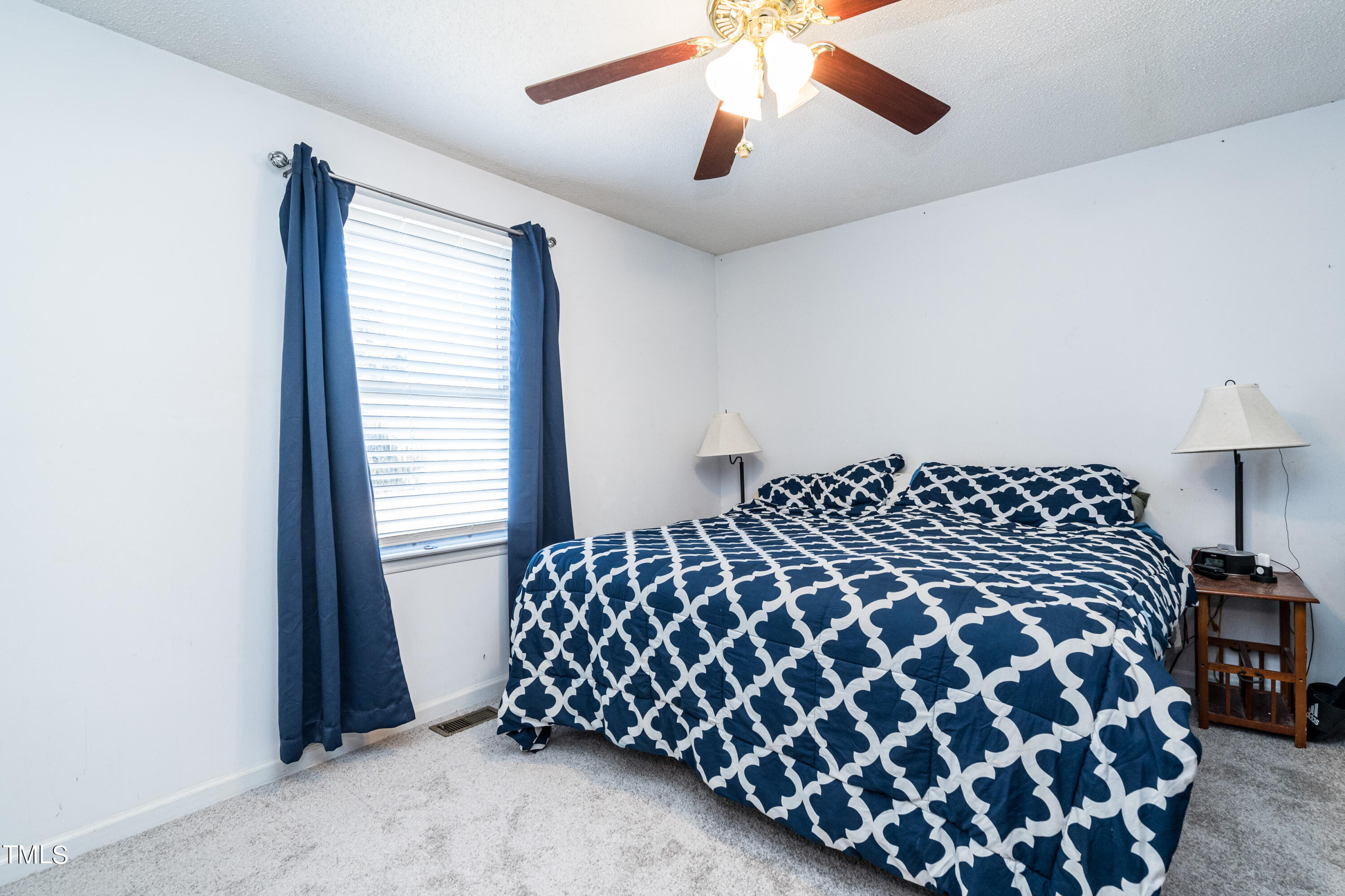 429 Government Road Clayton, NC 27520 - Photo 15 of 27 a large bed sitting in a bedroom next to a window and a chandelier