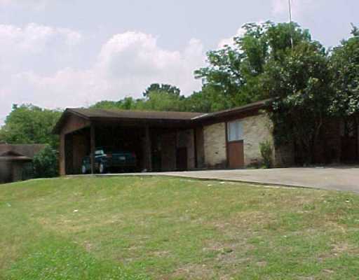 a front view of a house with a garden and trees