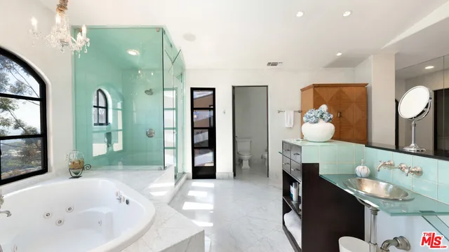 a bedroom with a bed couch and a large window