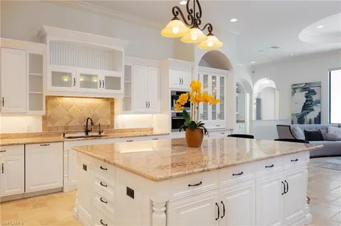 a kitchen with sink cabinets and chandelier