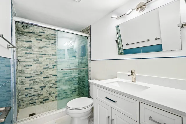 a bathroom with a sink a toilet and shower