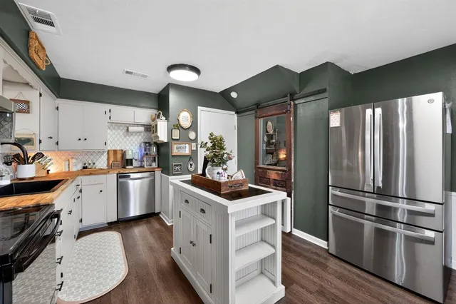 a kitchen with stainless steel appliances granite countertop a refrigerator a stove a sink dishwasher and a refrigerator