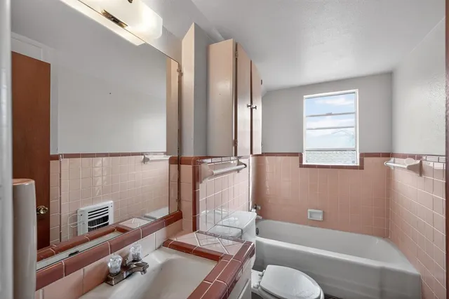 a bathroom with a tub sink and mirror