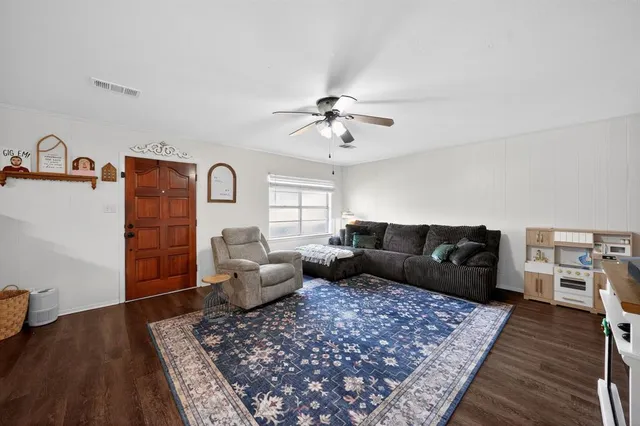 a living room with furniture and wooden floor