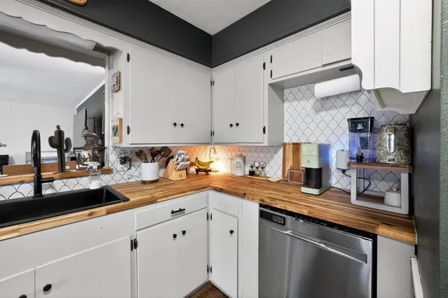 a kitchen with granite countertop white cabinets and white appliances