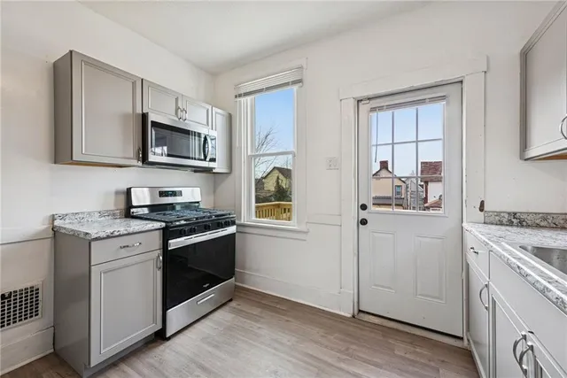 a kitchen with stainless steel appliances a stove microwave and sink