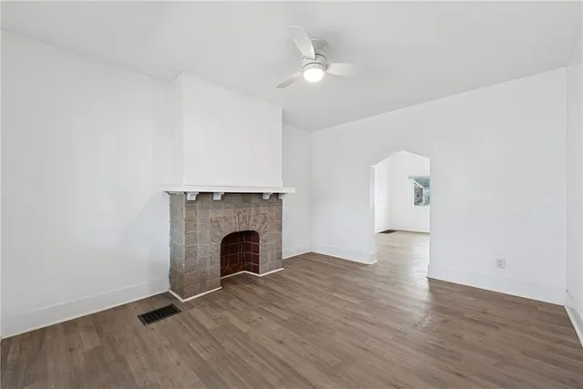 an empty room with wooden floor and fireplace