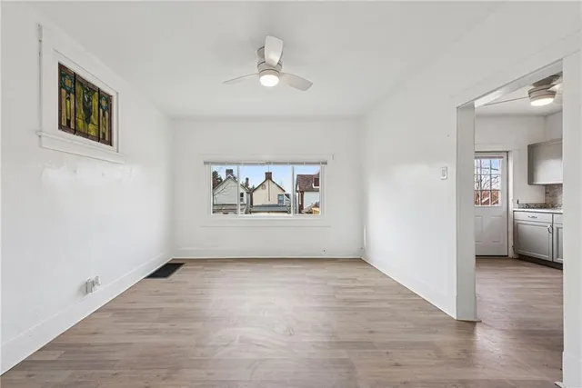 a view of a livingroom with wooden floor and a ceiling fan