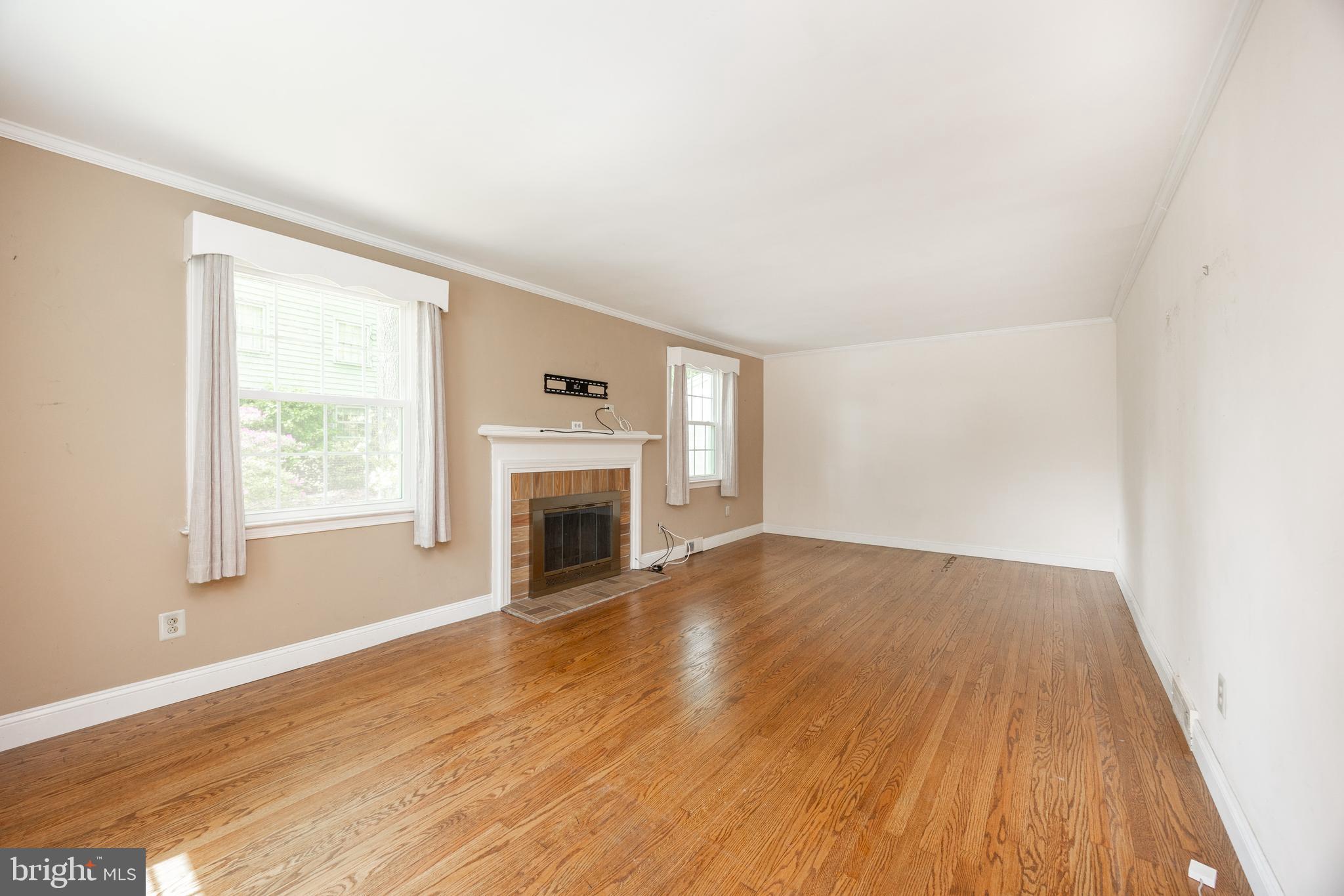 314 Spring Valley Road Springfield, PA 19064 - Photo 13 of 43 an empty room with wooden floor fireplace and windows