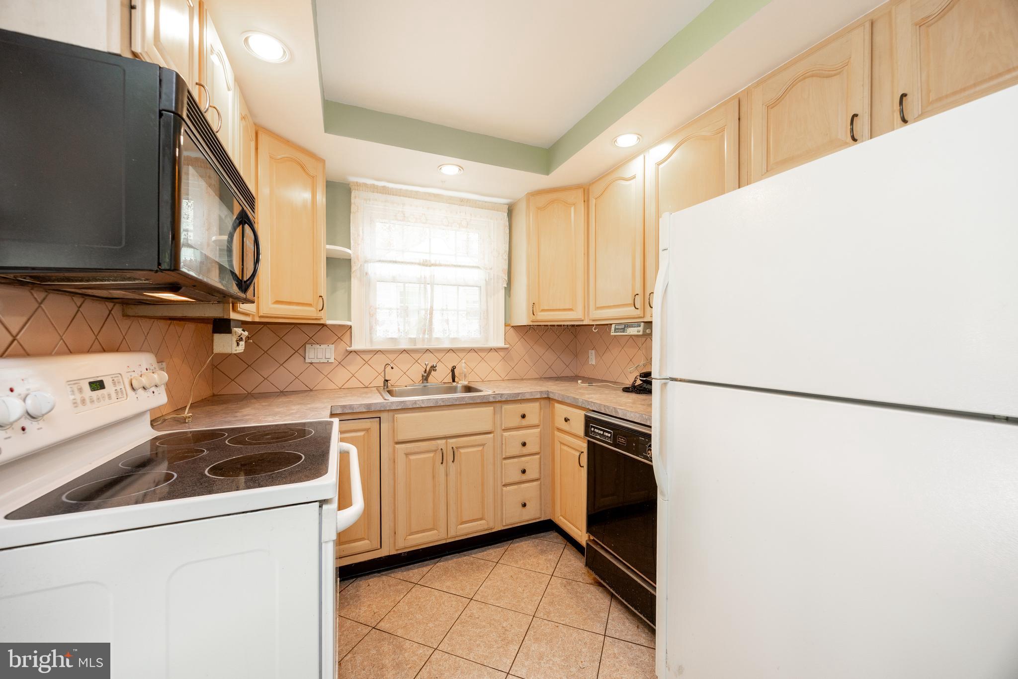 314 Spring Valley Road Springfield, PA 19064 - Photo 20 of 43 a kitchen with a sink a refrigerator and white cabinets