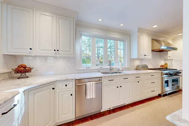 a kitchen with granite countertop white cabinets white stainless steel appliances with a sink and dishwasher