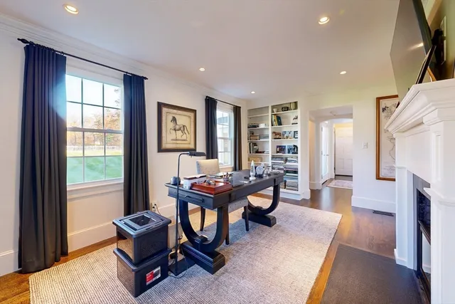 a living room with furniture a fireplace and a large window