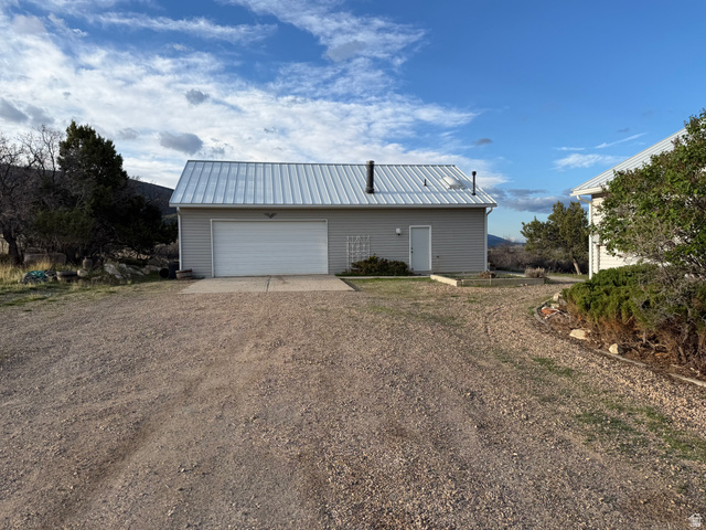 10000 North 6730th East Spring City, UT 84662 - Photo 4 of 31 Detached garage building featuring light gray siding and a white metal roof