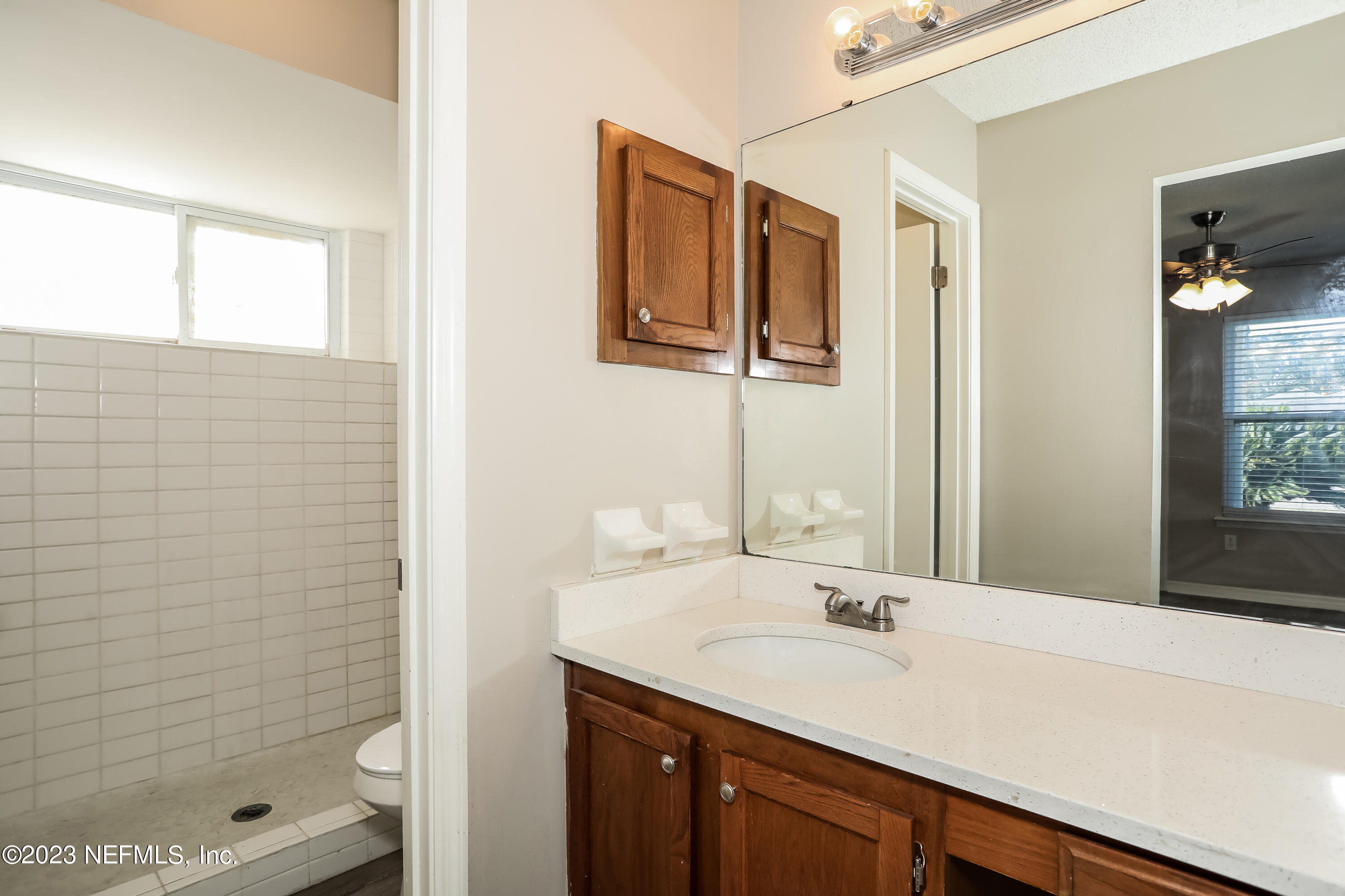 7684 Collins Ridge Boulevard Jacksonville, FL 32244 - Photo 10 of 15 a bathroom with a sink a shower and a mirror
