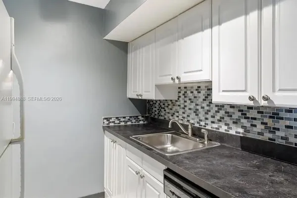 a kitchen with granite countertop a sink and cabinets