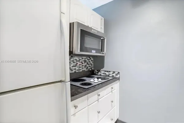a kitchen with granite countertop a stove and a microwave