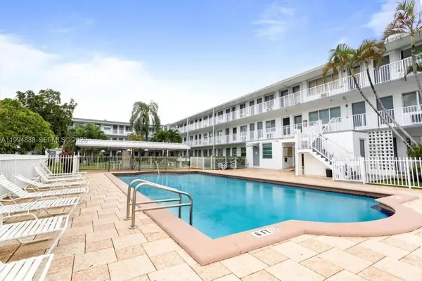 a view of a house with pool and sitting area