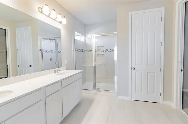 a spacious bathroom with a shower sink and mirror
