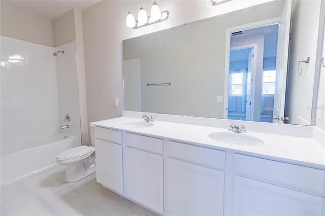a bathroom with a double vanity sink mirror and toilet