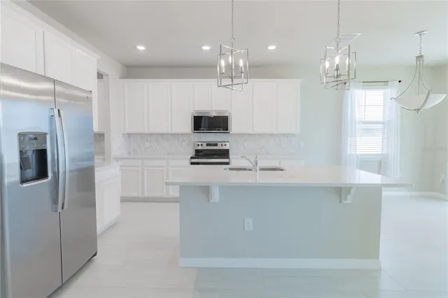 a kitchen with kitchen island white cabinets and stainless steel appliances
