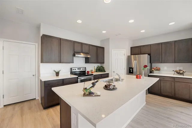 a kitchen with refrigerator cabinets dining table and chairs