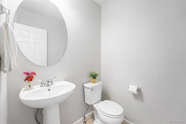 a bathroom with a sink mirror and a toilet