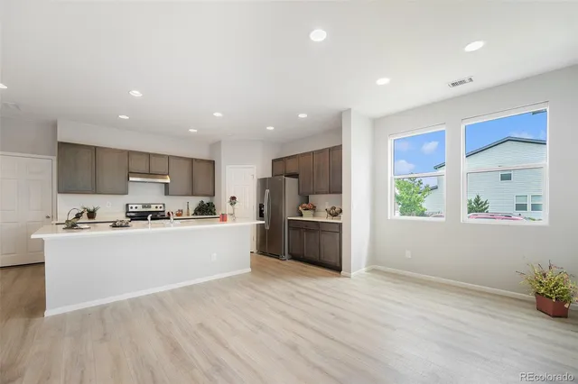 a kitchen with stainless steel appliances a white wooden cabinets and window