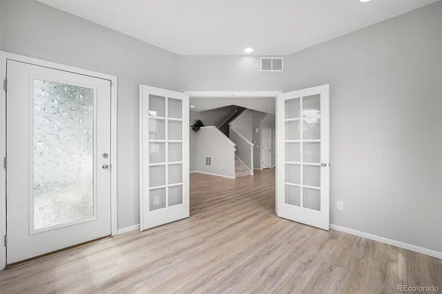an empty room with wooden floor and windows
