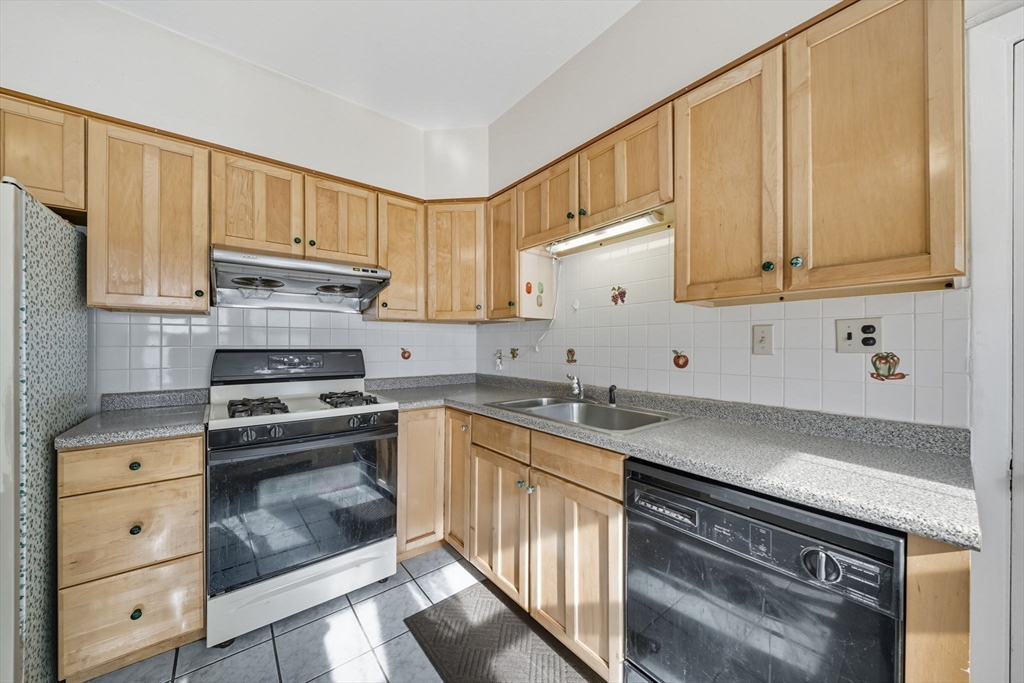 28 Verndale Street Brookline, MA 02446 - Photo 19 of 42 a kitchen with granite countertop cabinets stainless steel appliances and a sink