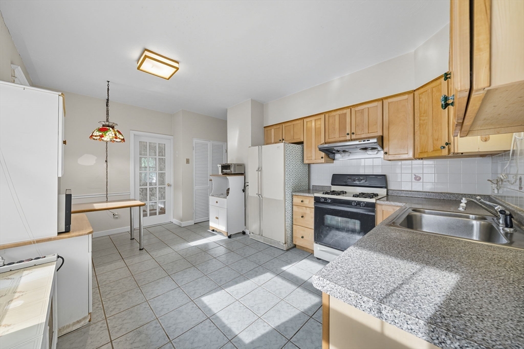 28 Verndale Street Brookline, MA 02446 - Photo 20 of 42 a kitchen with granite countertop a sink cabinets and stainless steel appliances