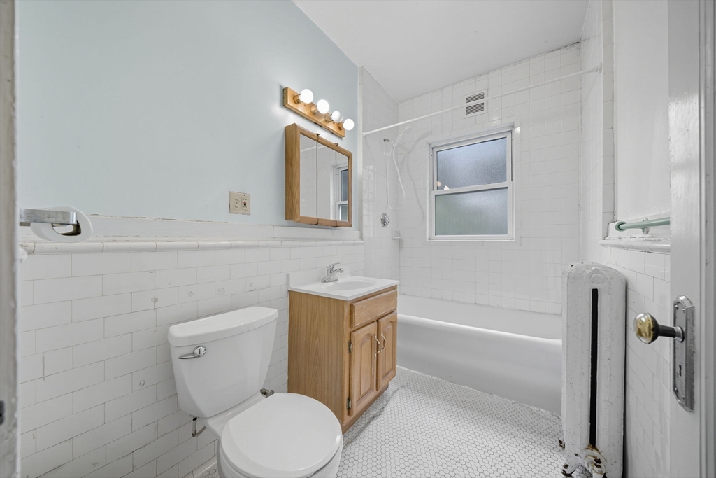 28 Verndale Street Brookline, MA 02446 - Photo 6 of 42 a bathroom with a toilet a sink a mirror and bathtub