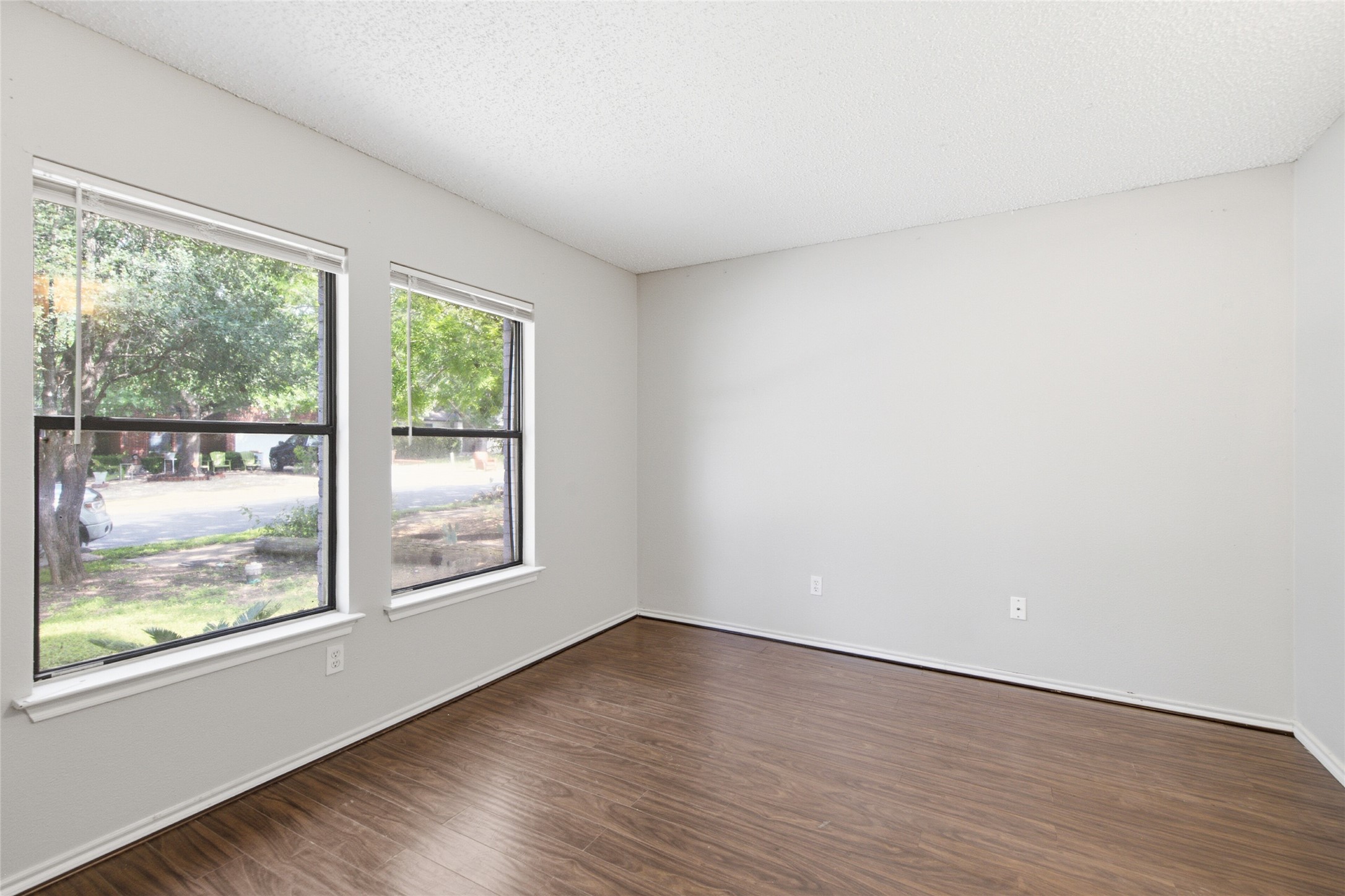 7900 Rosenberry Drive Austin, TX 78747 - Photo 3 of 27 Hardwood-style flooring and two ample windows define this adaptable room, ready for your personal touch.