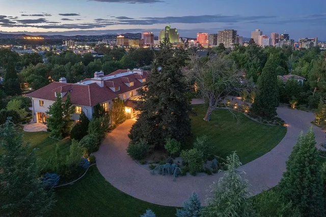 an aerial view of a house with garden space lake and mountain view in back