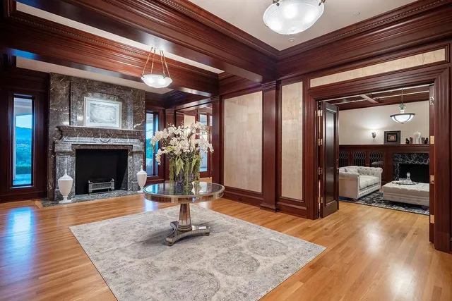 a view of a hallway with wooden floor and a fireplace