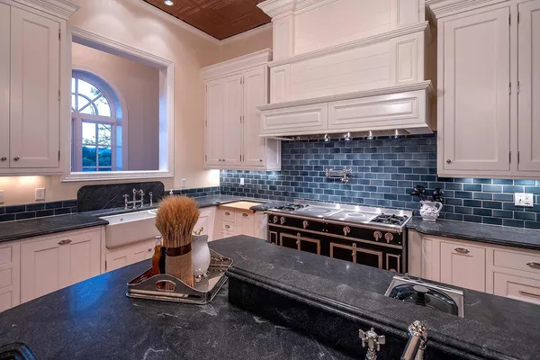 a kitchen with a stove a sink and cabinets